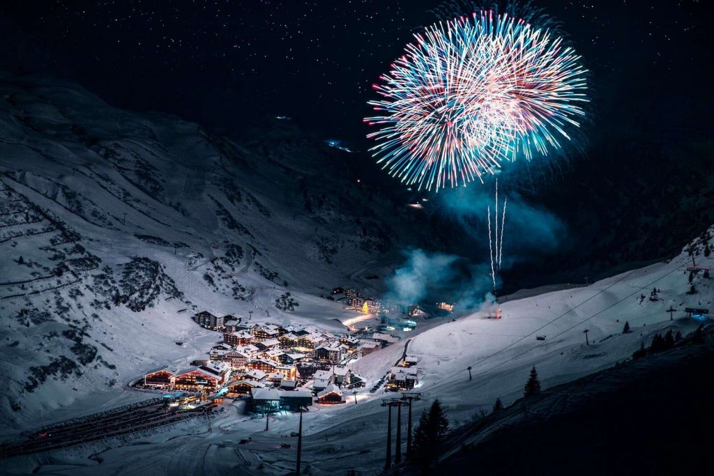 Fuochi d'artificio sopra il villaggio di montagna invernale