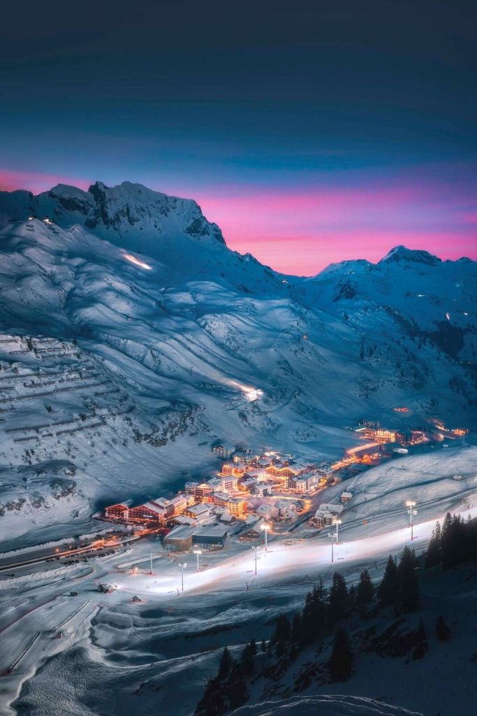 Villaggio innevato sotto un cielo serale viola