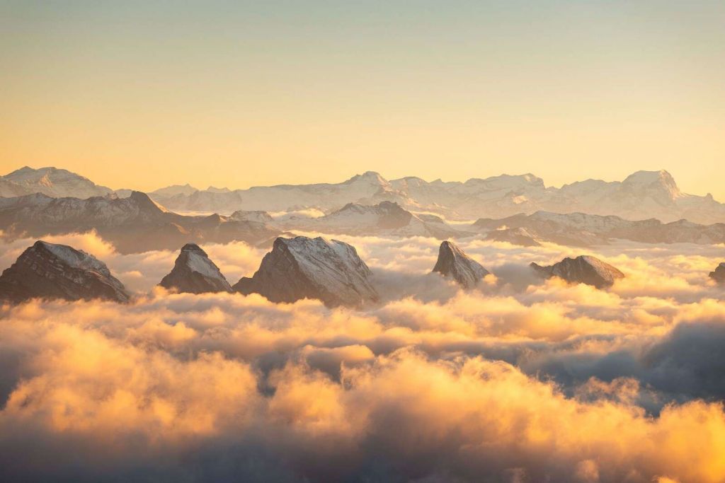 Cime montuose sopra un mare di nuvole dorate