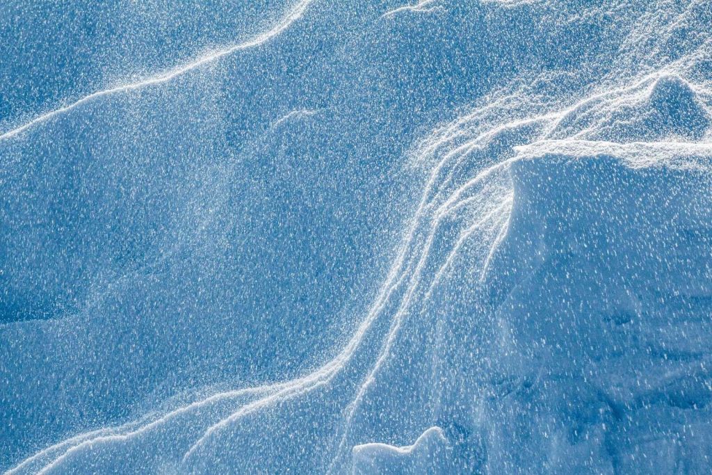 Neve vorticante su paesaggio blu ghiacciato