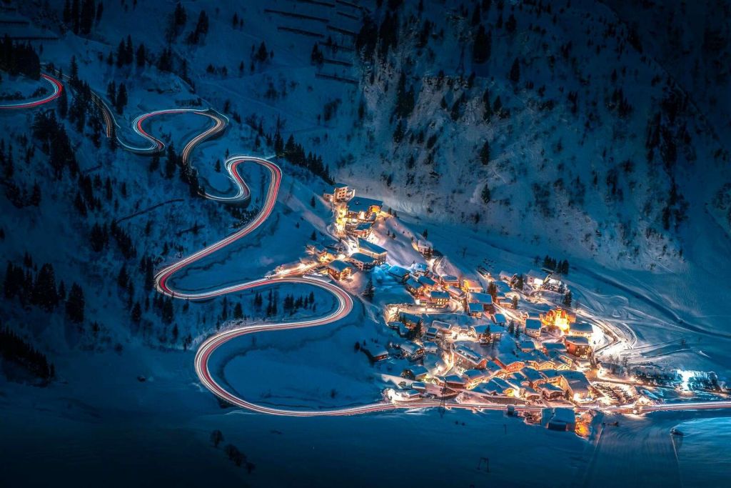 Villaggio di montagna illuminato con strada di montagna tortuosa