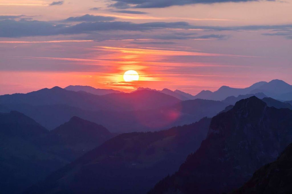 Tramonto sopra strati di montagne viola