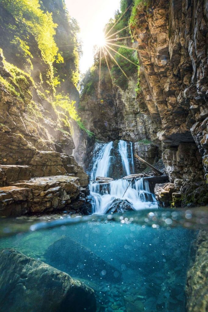 Luce solare sulla cascata di montagna