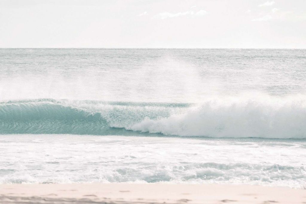 Onda che si infrange su una spiaggia limpida