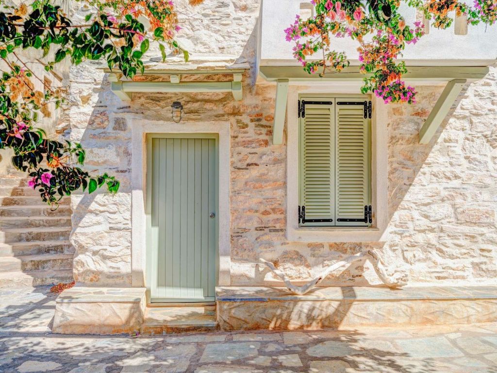 Facciata in pietra mediterranea con bougainvillea