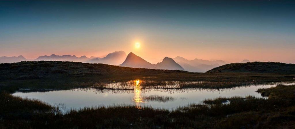 Sole della sera sopra un lago di montagna