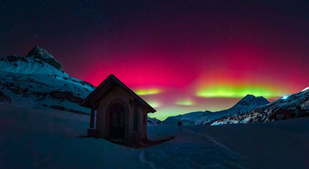 Aurora boreale sopra montagne innevate