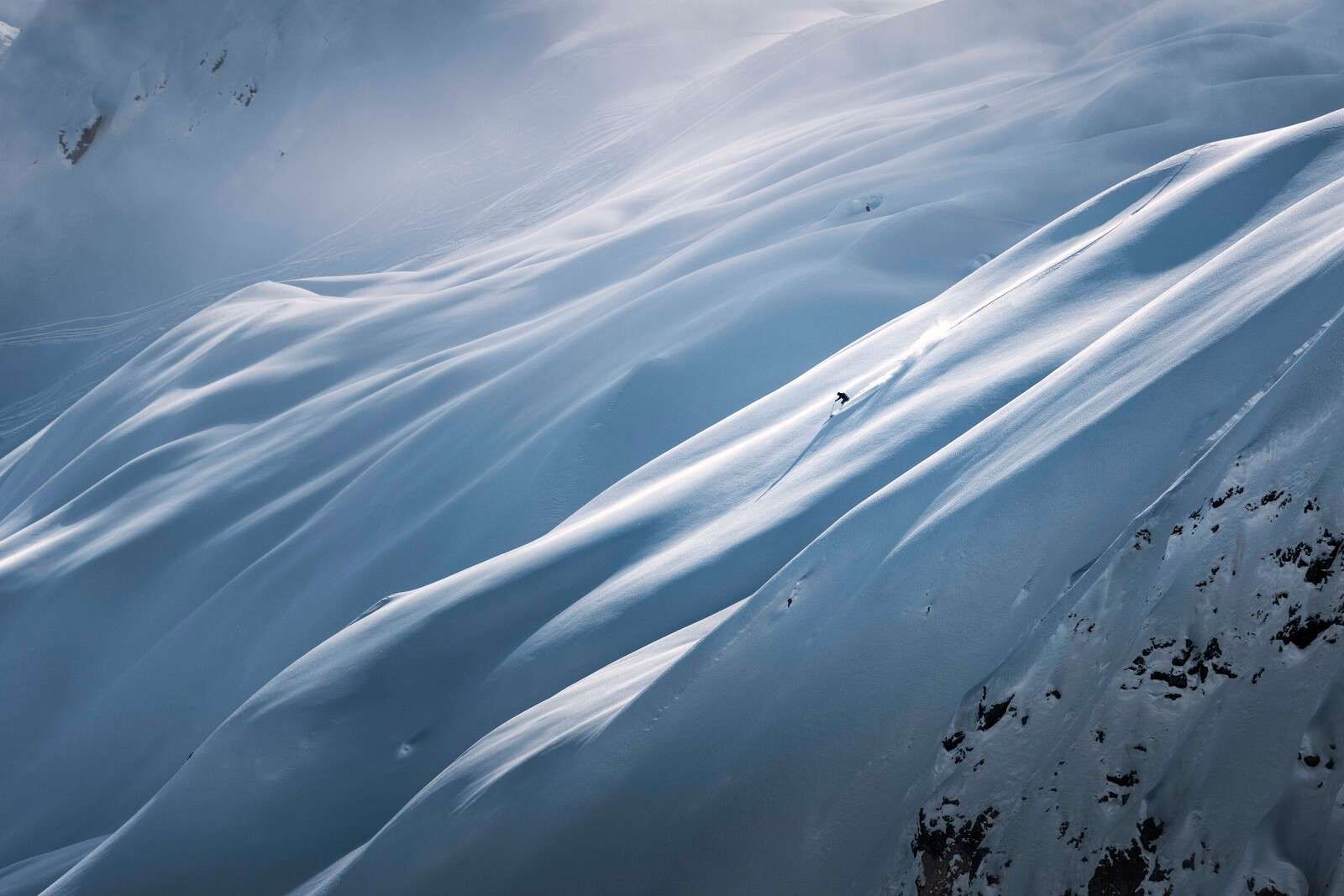 Discesa in freeride su pendio innevato.