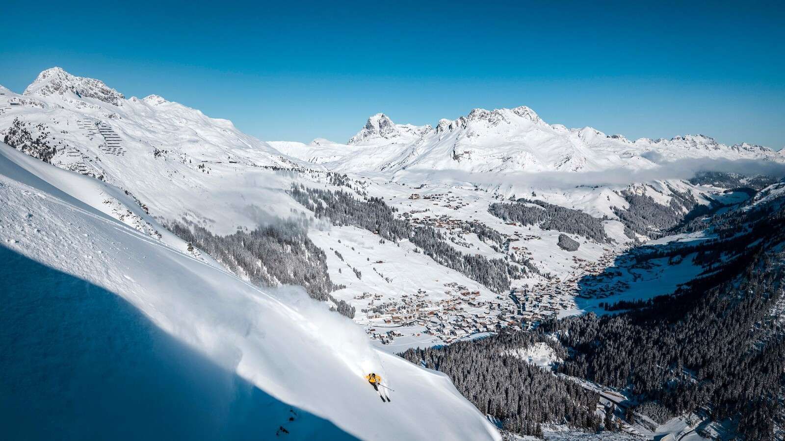 Discesa sopra il villaggio alpino nella neve.