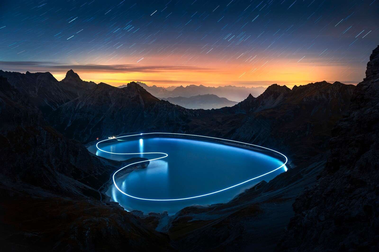 Luce pad intorno al lago di montagna di notte