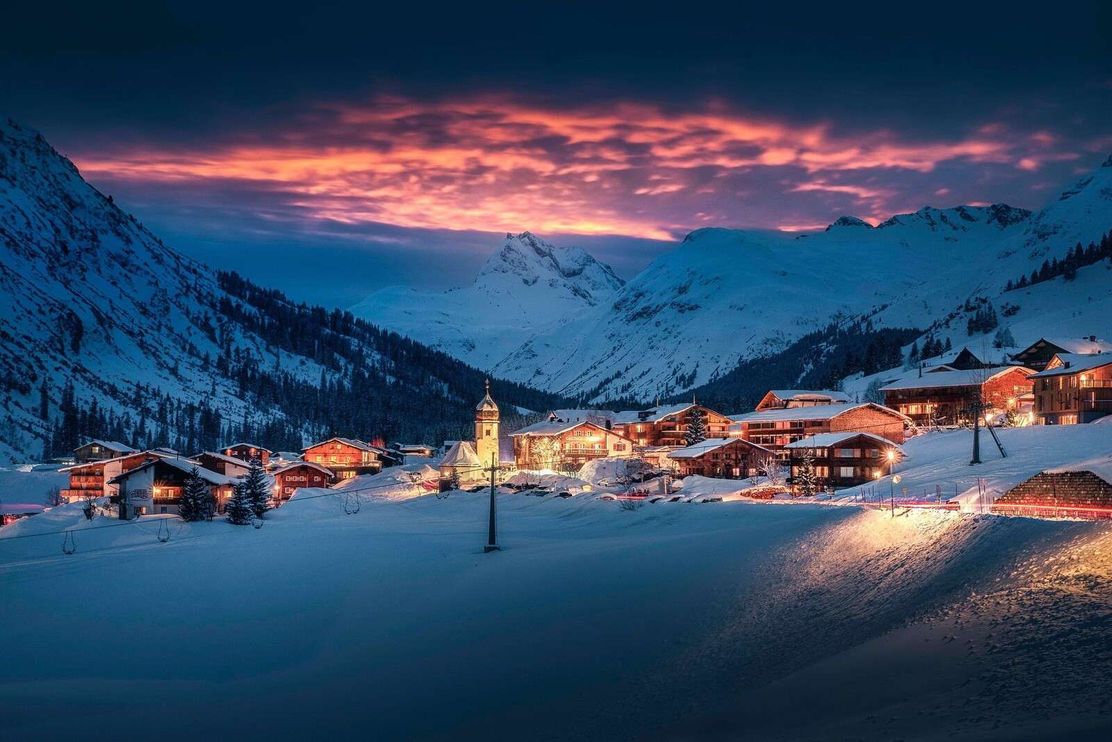 Luce del tramonto su un villaggio di montagna nella neve
