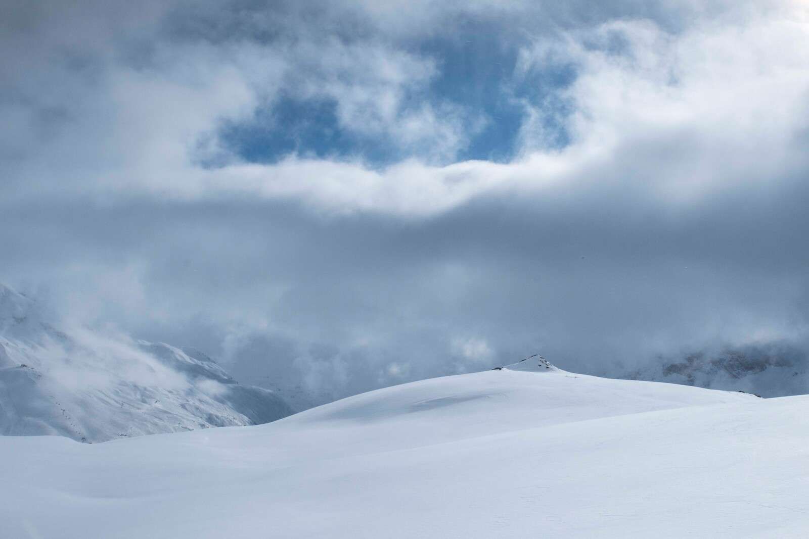 Colline innevate sotto un cielo minaccioso