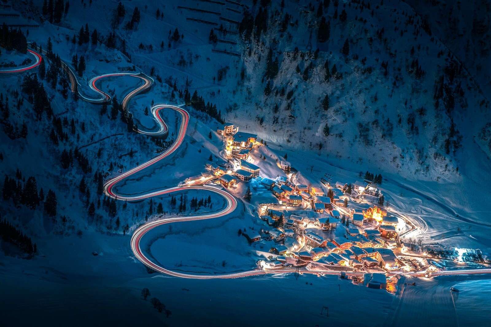 Villaggio di montagna illuminato con strada di montagna tortuosa
