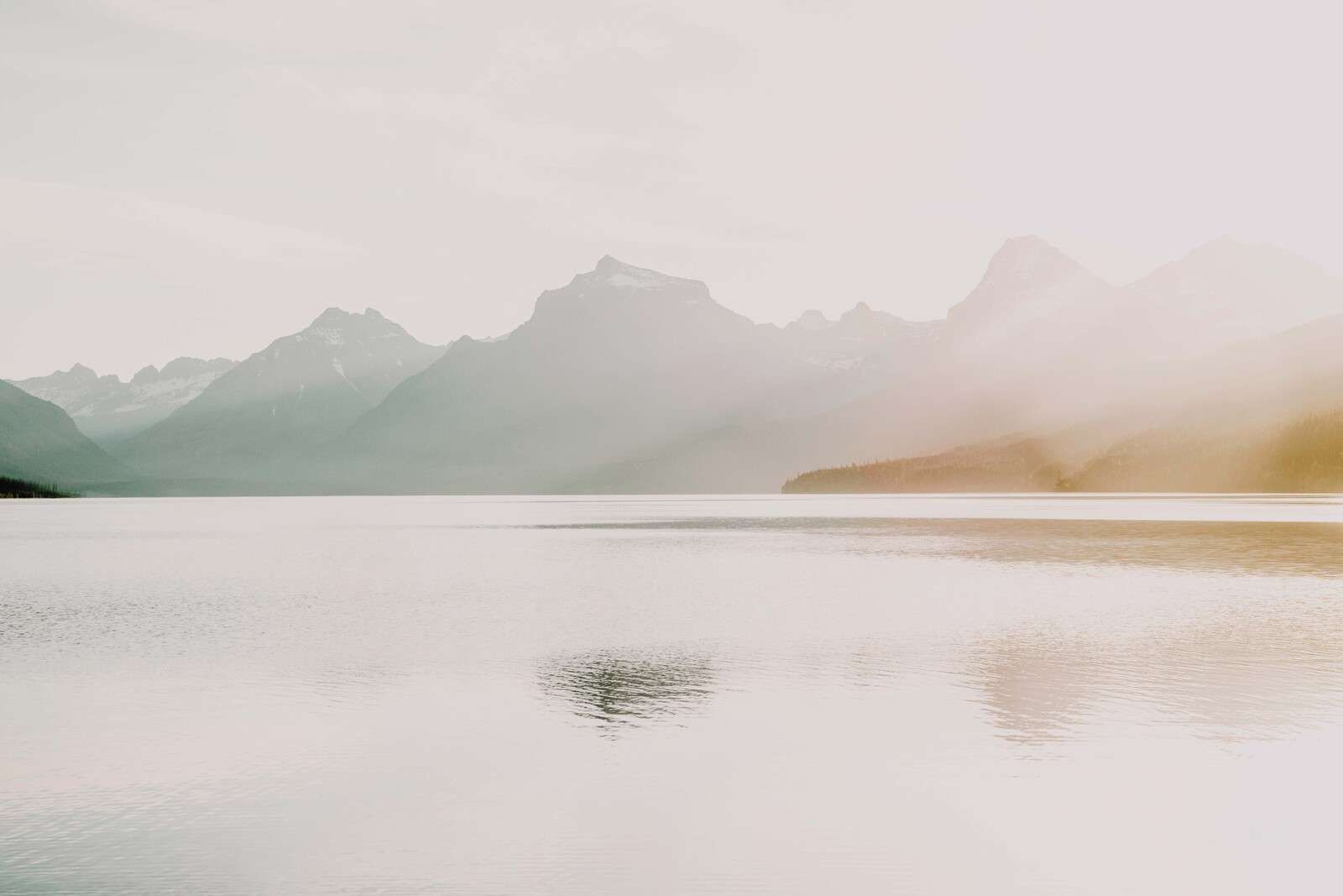 Montagne nebbiose sopra un lago tranquillo