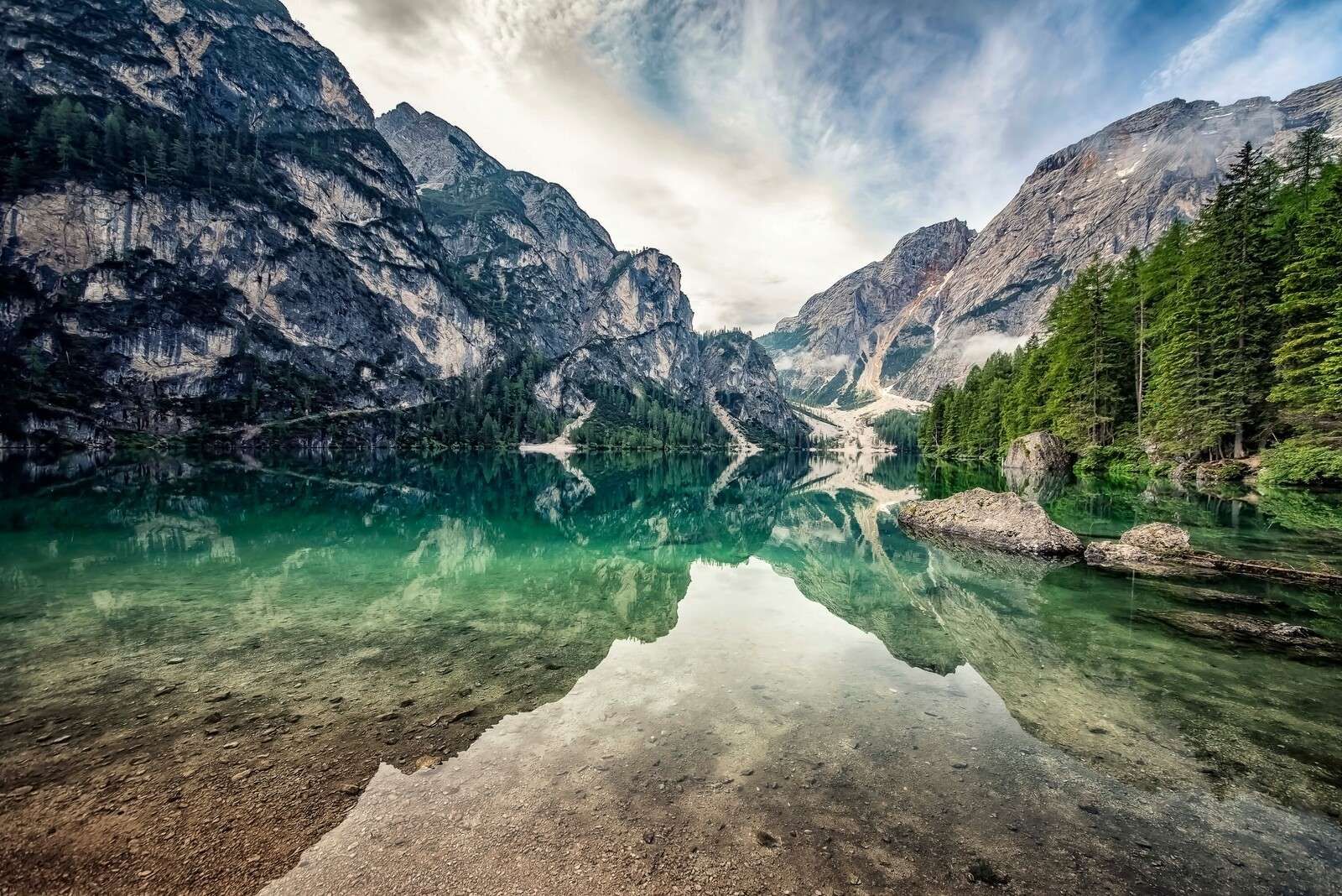 Lago di montagna smeraldo con pareti rocciose.